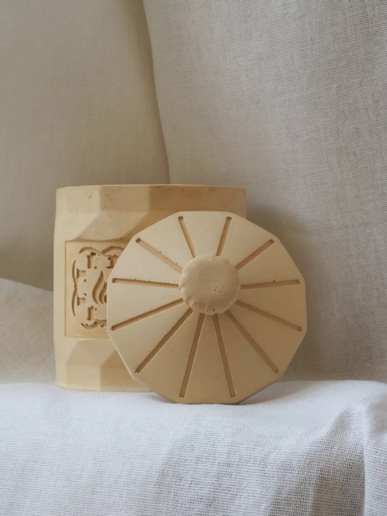 Flamme d’Élixir architectural candle in minimalist artist studio setting.