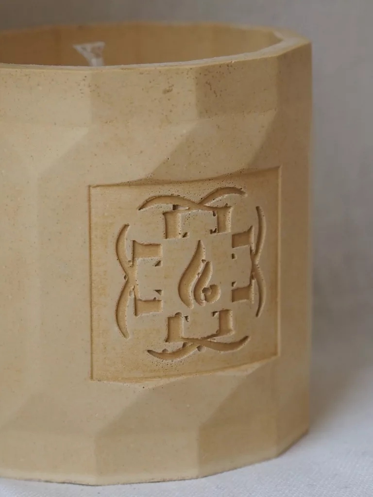 Flamme d’Élixir architectural candle in minimalist artist studio setting.