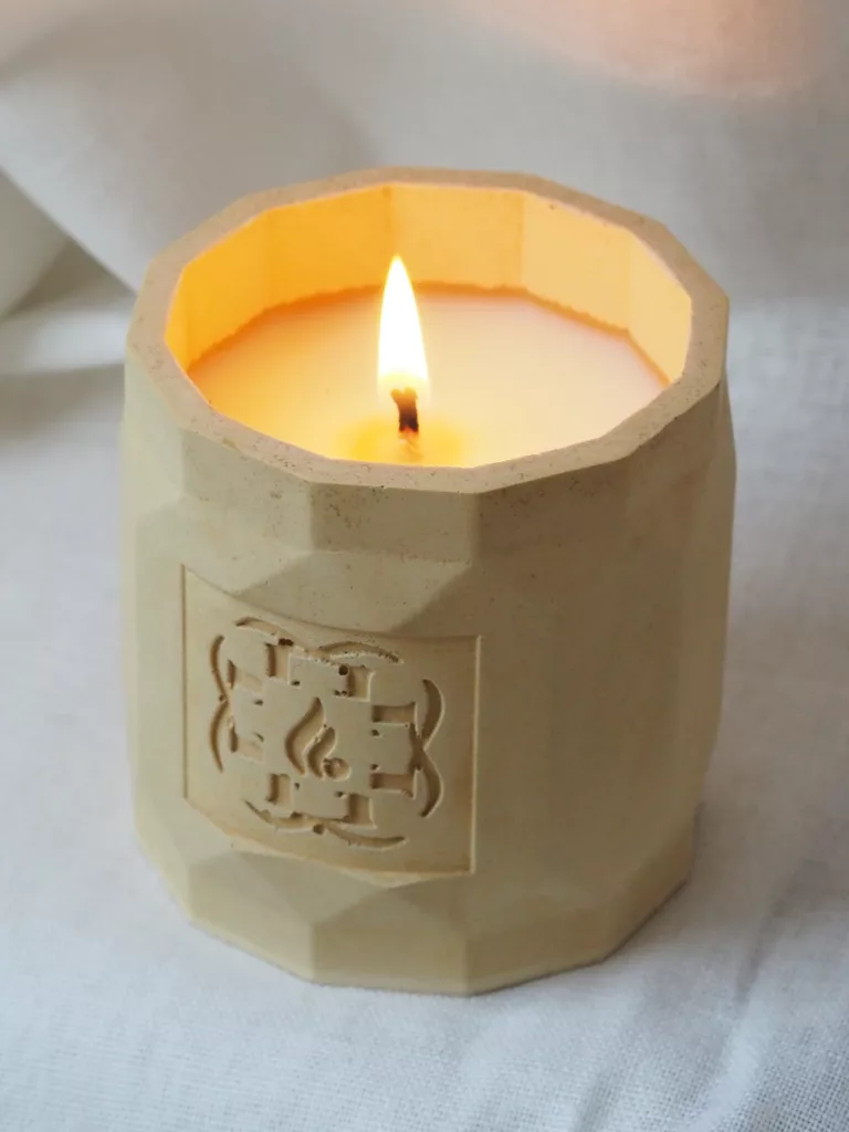 Flamme d’Élixir architectural candle in minimalist artist studio setting.