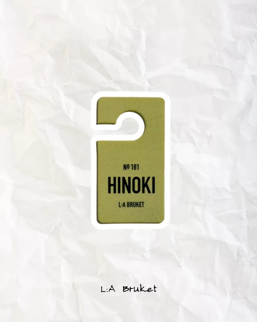 L:A Bruket Hinoki home fragrance label on a minimal, design-inspired background.