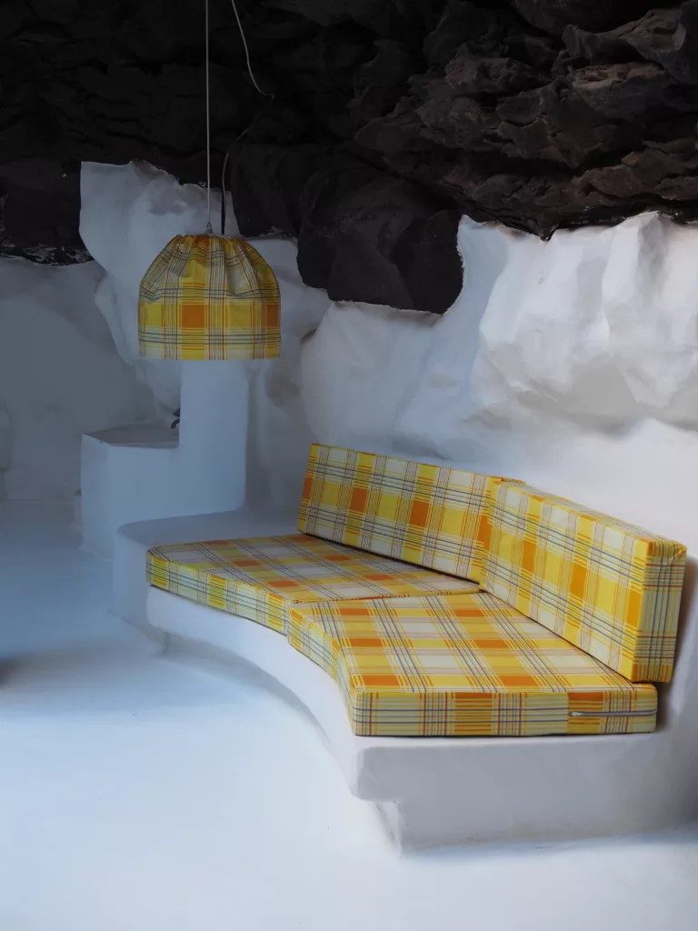 Interior view of César Manrique's foundation in Lanzarote with volcanic rock and sofa.