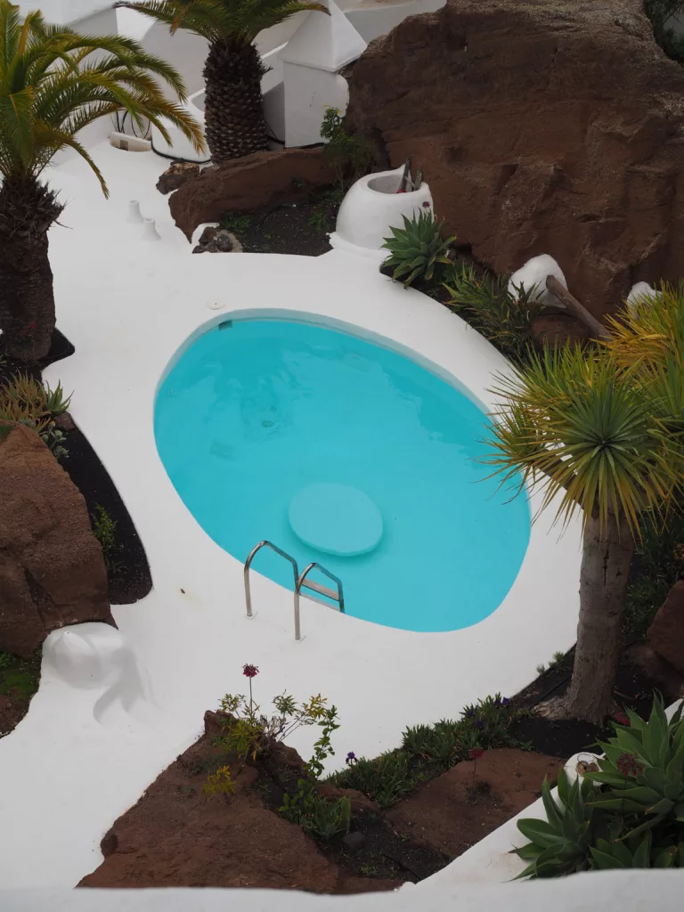 Interior view of Lagomar in Lanzarote showing pool in rock landscape.