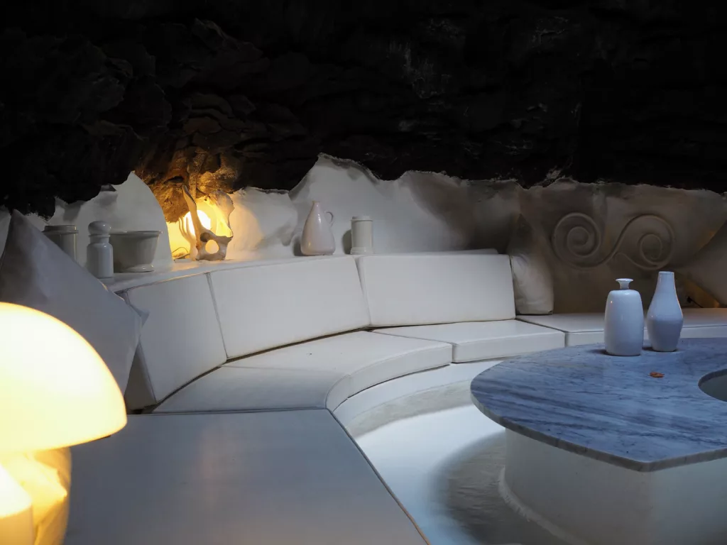 Interior view of César Manrique's foundation in Lanzarote with volcanic rock wall and a minimalistic white sofa.