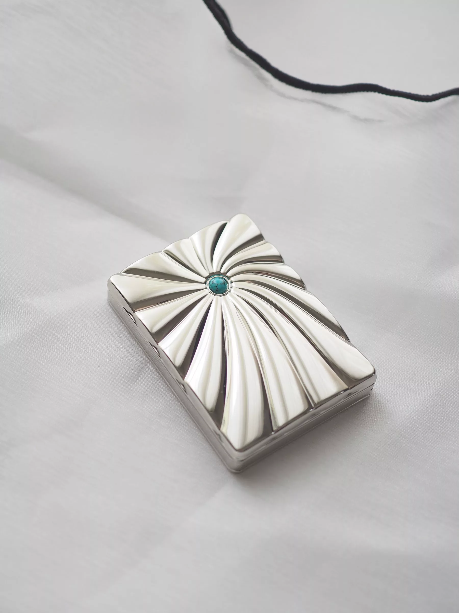 A silver case of Batchig solid perfume